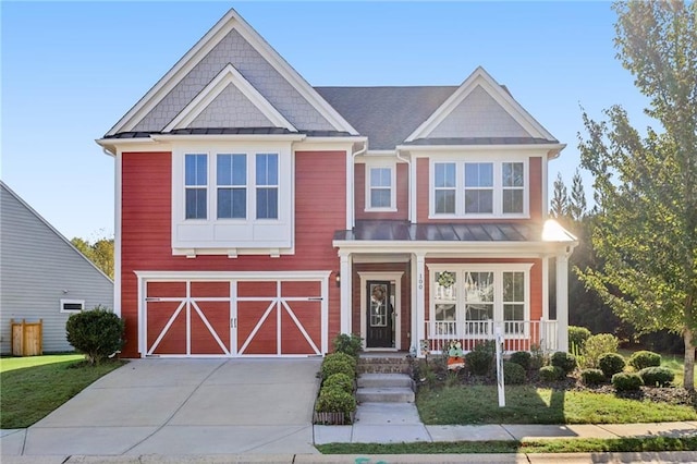 view of front of home featuring a standing seam roof, a porch, metal roof, an attached garage, and driveway