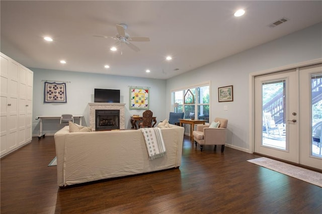 living room featuring recessed lighting, a fireplace, dark wood finished floors, and french doors