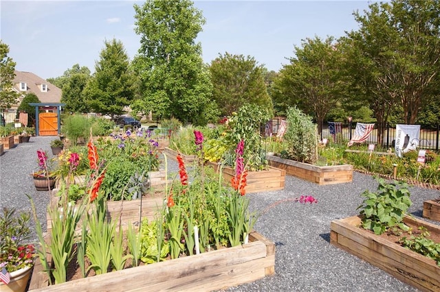 view of community with a vegetable garden and fence