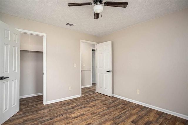 unfurnished bedroom featuring wood finished floors, baseboards, a closet, and a textured ceiling