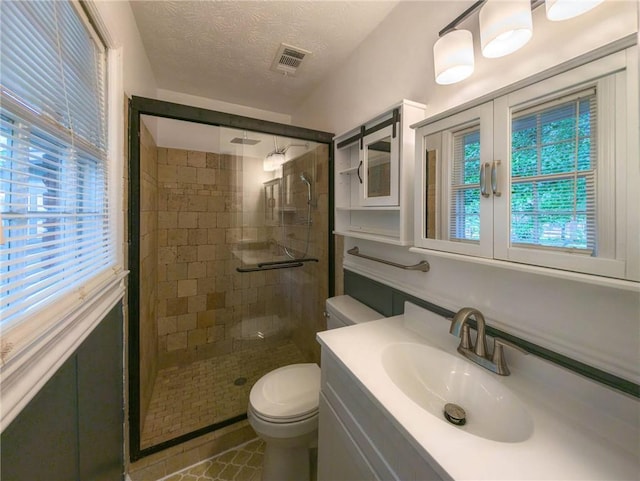 full bathroom with toilet, a stall shower, vanity, and a textured ceiling