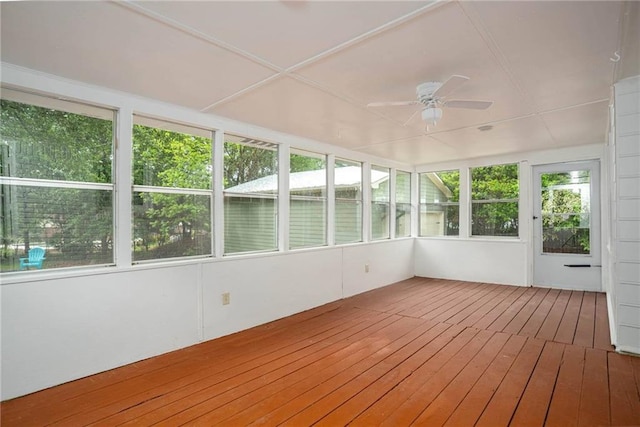 unfurnished sunroom featuring ceiling fan, a deck, and hardwood / wood-style floors