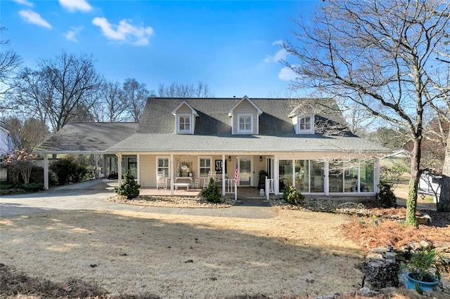 farmhouse-style home with covered porch, a carport, and driveway