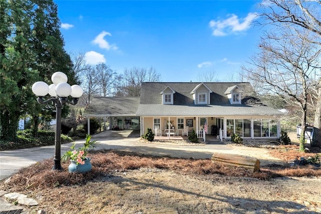 farmhouse-style home with a carport, a porch, and driveway