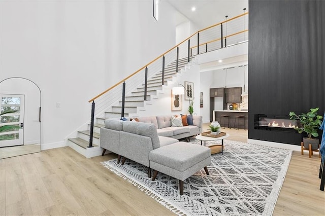 living room with light wood-type flooring and a high ceiling