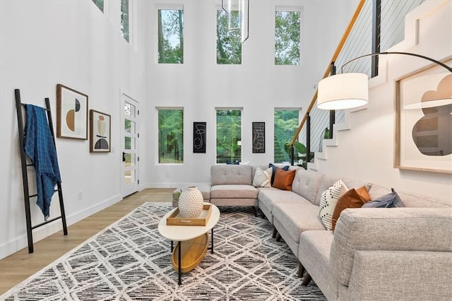 living room with a high ceiling, a healthy amount of sunlight, and wood-type flooring