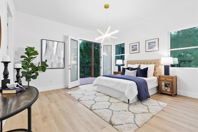 bedroom with access to outside, light hardwood / wood-style flooring, and an inviting chandelier