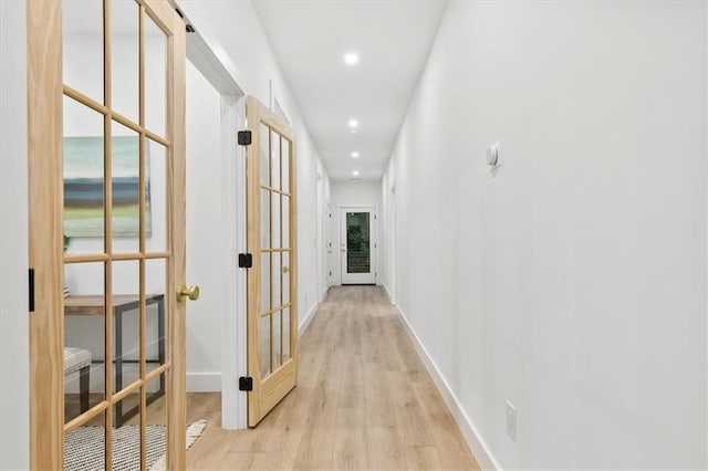 hallway featuring french doors and light wood-type flooring