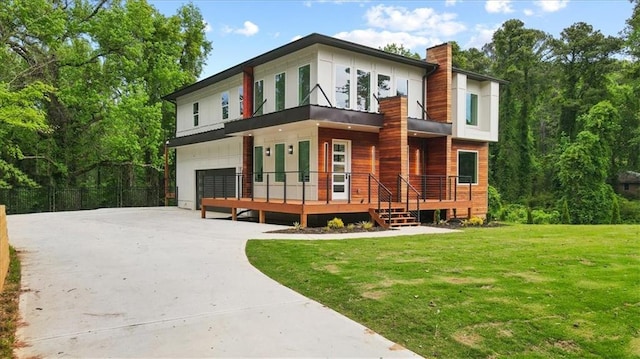 back of property with a garage, a yard, and a wooden deck