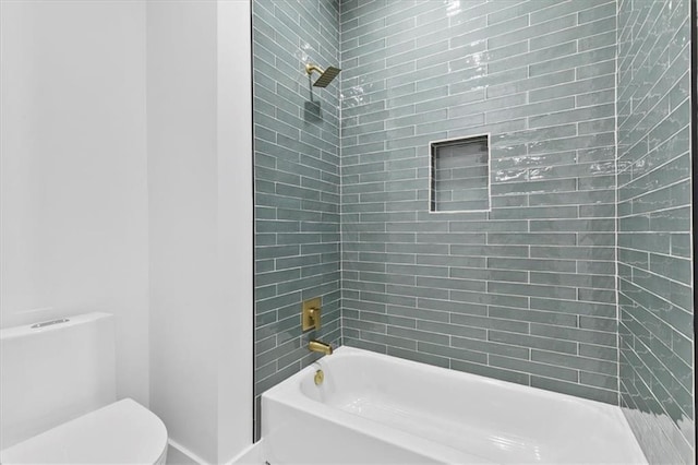 bathroom with tiled shower / bath combo and toilet