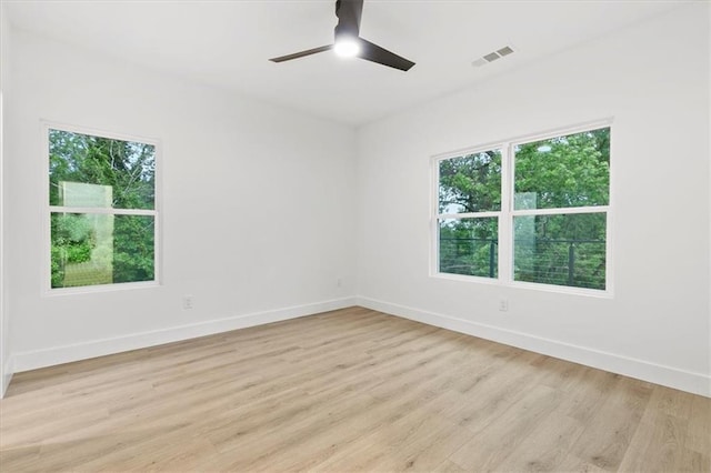 empty room with ceiling fan and light hardwood / wood-style flooring