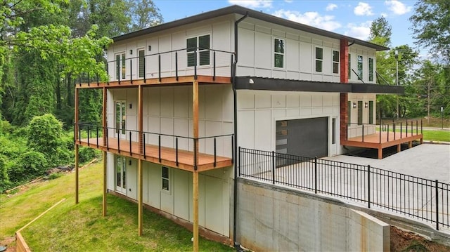 back of property with a lawn and a garage