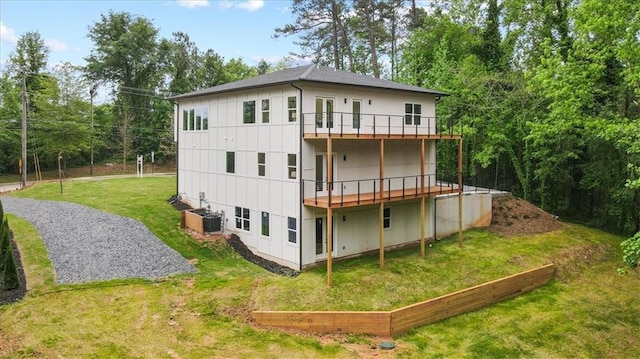 back of property with a balcony, central AC, and a lawn