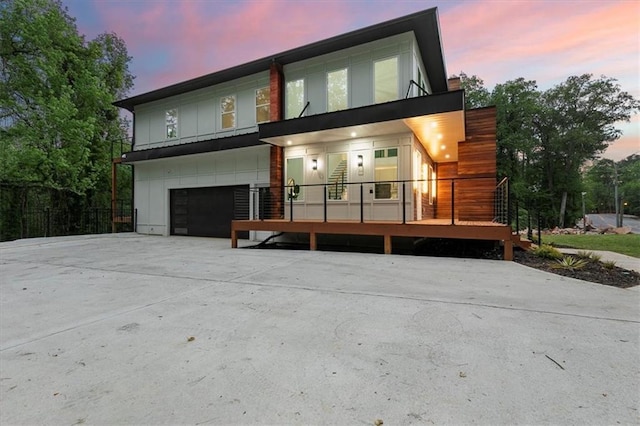 back house at dusk featuring a garage