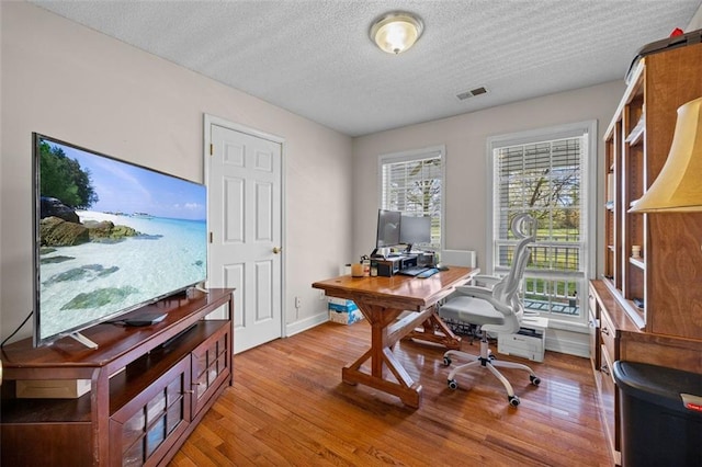 office featuring a textured ceiling and light hardwood / wood-style floors