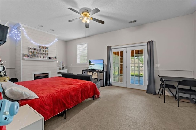 carpeted bedroom with multiple windows, ceiling fan, access to outside, and a textured ceiling