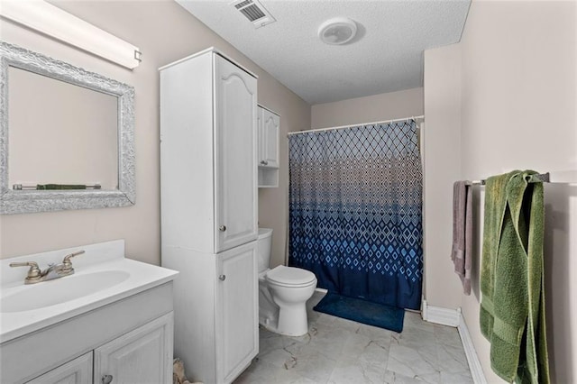 bathroom featuring walk in shower, vanity, toilet, and a textured ceiling