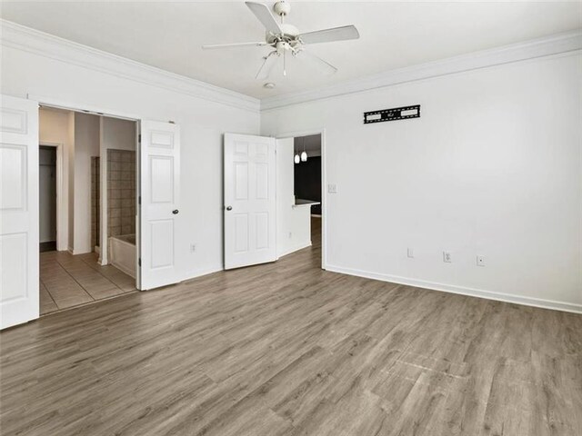 unfurnished bedroom with hardwood / wood-style flooring, ceiling fan, ornamental molding, and connected bathroom