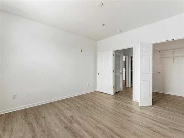 unfurnished bedroom with light wood-type flooring and a closet