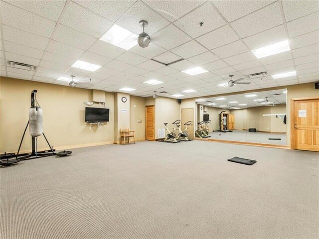 workout area featuring carpet flooring and a paneled ceiling