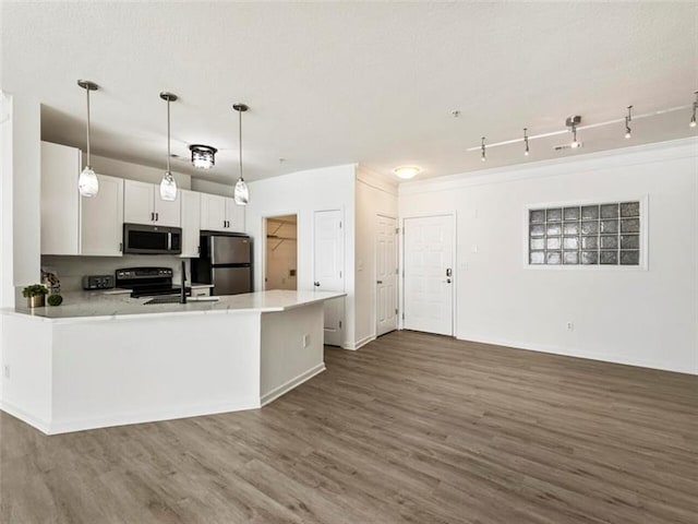 kitchen featuring appliances with stainless steel finishes, sink, dark hardwood / wood-style floors, white cabinetry, and hanging light fixtures