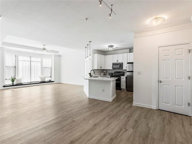 kitchen featuring sink, electric range, white cabinets, stainless steel refrigerator, and hanging light fixtures