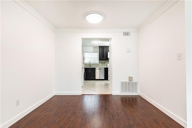 empty room featuring ornamental molding, washer / dryer, and dark hardwood / wood-style floors