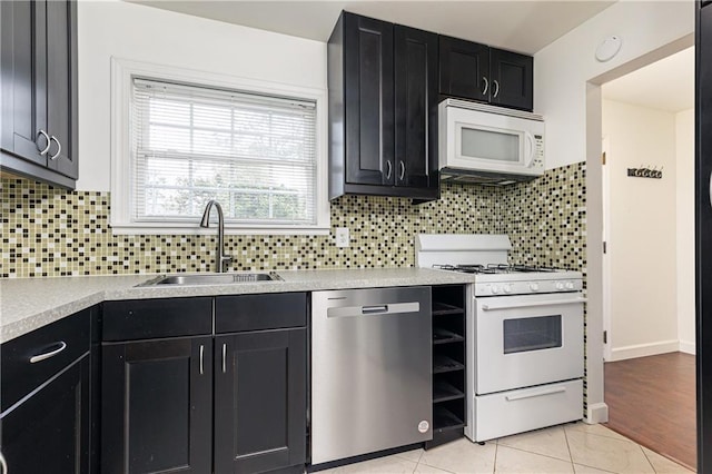 kitchen featuring tasteful backsplash, sink, white appliances, and light tile patterned flooring