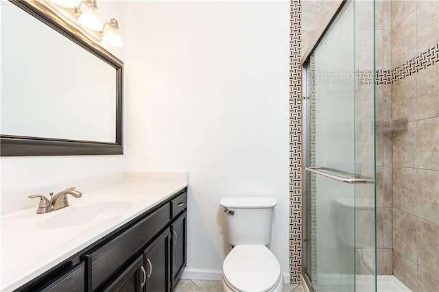 bathroom featuring tile patterned floors, toilet, a shower with door, and vanity