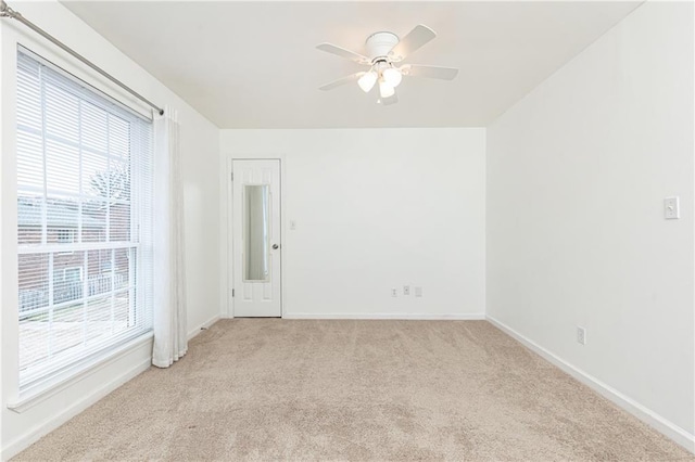 spare room featuring ceiling fan and light carpet