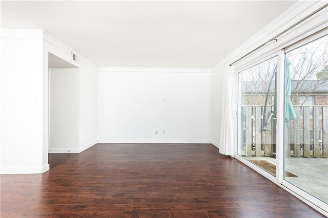 spare room with ornamental molding and dark wood-type flooring