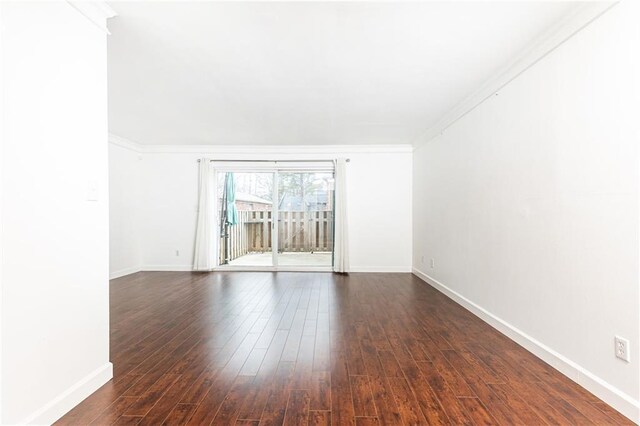 spare room with dark wood-type flooring and ornamental molding