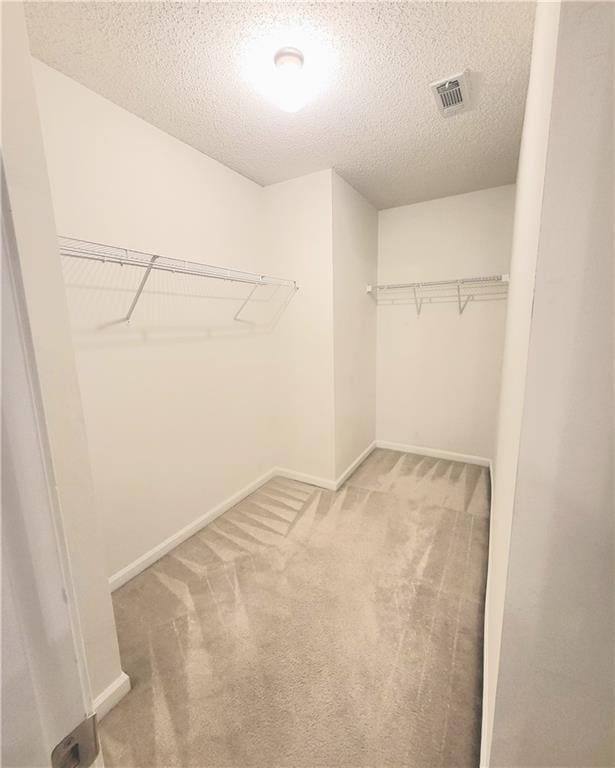 walk in closet featuring carpet and visible vents