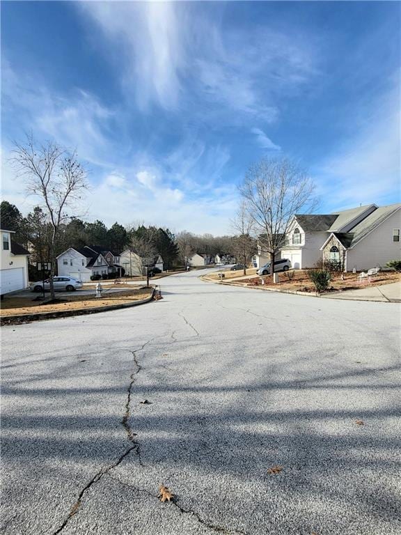 view of road featuring a residential view and curbs