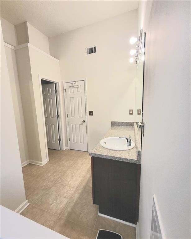 bathroom with visible vents, vanity, baseboards, and tile patterned floors