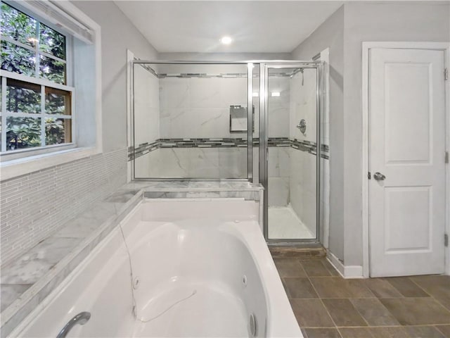 bathroom with shower with separate bathtub and a healthy amount of sunlight