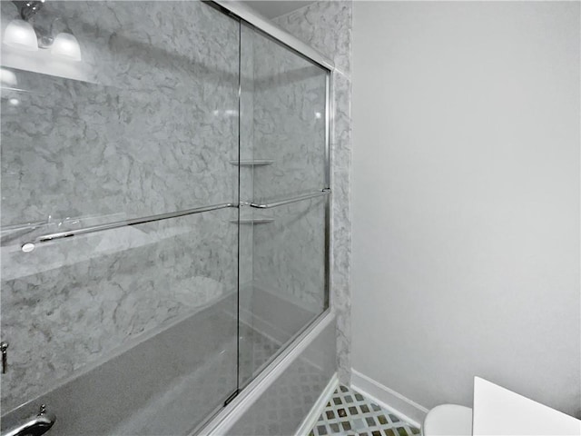 2122 Belhaven Ln SE, Atlanta, GA 30315 - bathroom with toilet, baseboards, and bath / shower combo with glass door