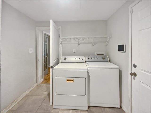 washroom featuring light tile patterned floors and washing machine and dryer