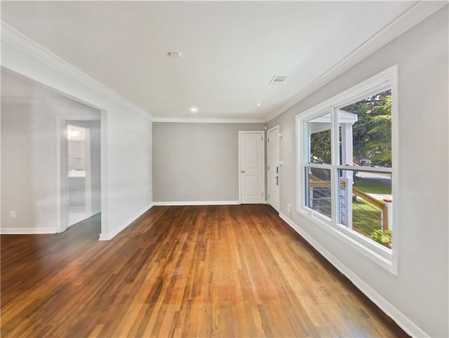 unfurnished room with ornamental molding, plenty of natural light, and hardwood / wood-style floors