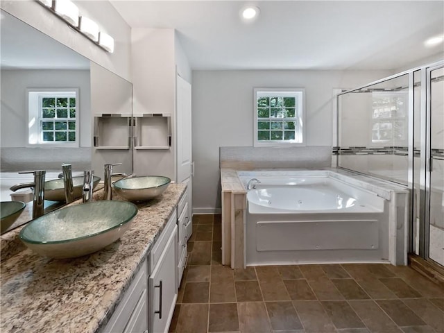 2122 Belhaven Ln SE, Atlanta, GA 30315 - bathroom featuring a tub with jets, a healthy amount of sunlight, a sink, and a stall shower