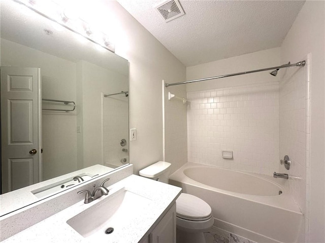 full bathroom featuring vanity, a textured ceiling, tiled shower / bath combo, and toilet