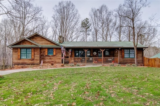 cabin featuring a porch and a front lawn