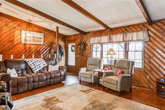 living room featuring wood walls, a textured ceiling, dark hardwood / wood-style floors, and beam ceiling