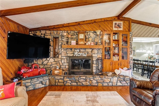 living room featuring wooden walls, lofted ceiling with beams, hardwood / wood-style floors, and a fireplace