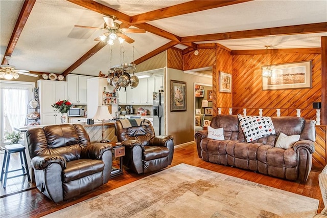 living room with ceiling fan, vaulted ceiling with beams, and dark wood-type flooring