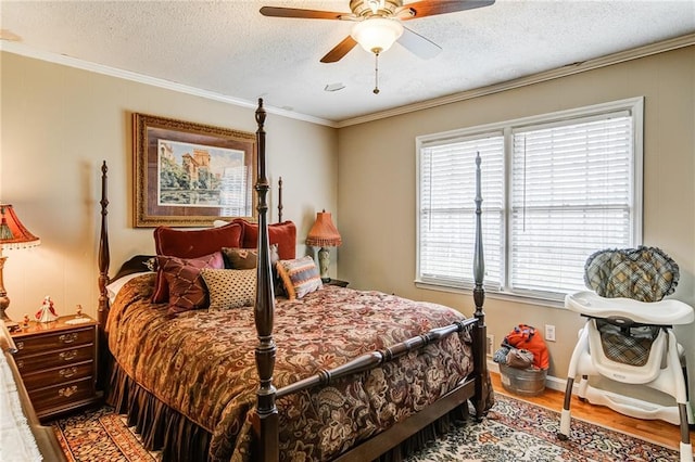 bedroom featuring ceiling fan, a textured ceiling, crown molding, and wood-type flooring