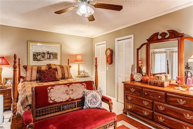 bedroom featuring multiple closets, a textured ceiling, ceiling fan, and ornamental molding