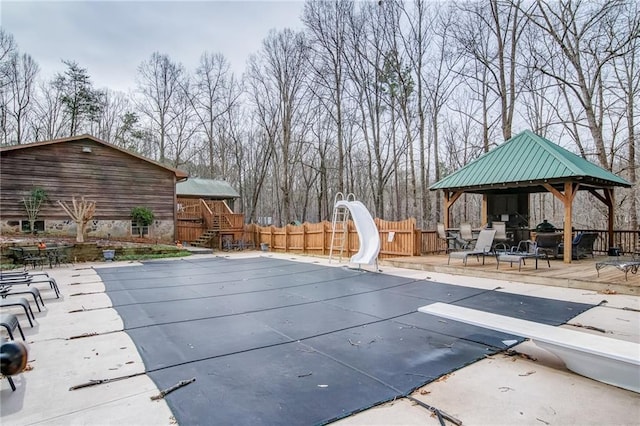 view of pool featuring a gazebo, a water slide, a diving board, and a patio