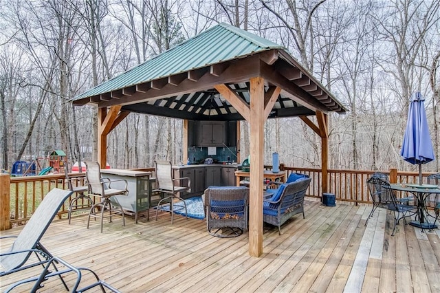 wooden terrace with a gazebo and a playground