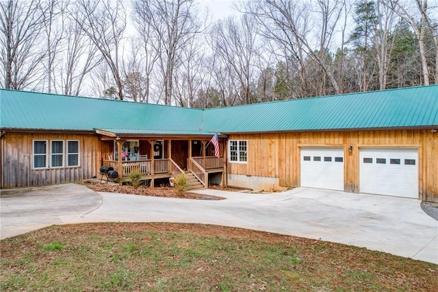 single story home featuring covered porch and a garage